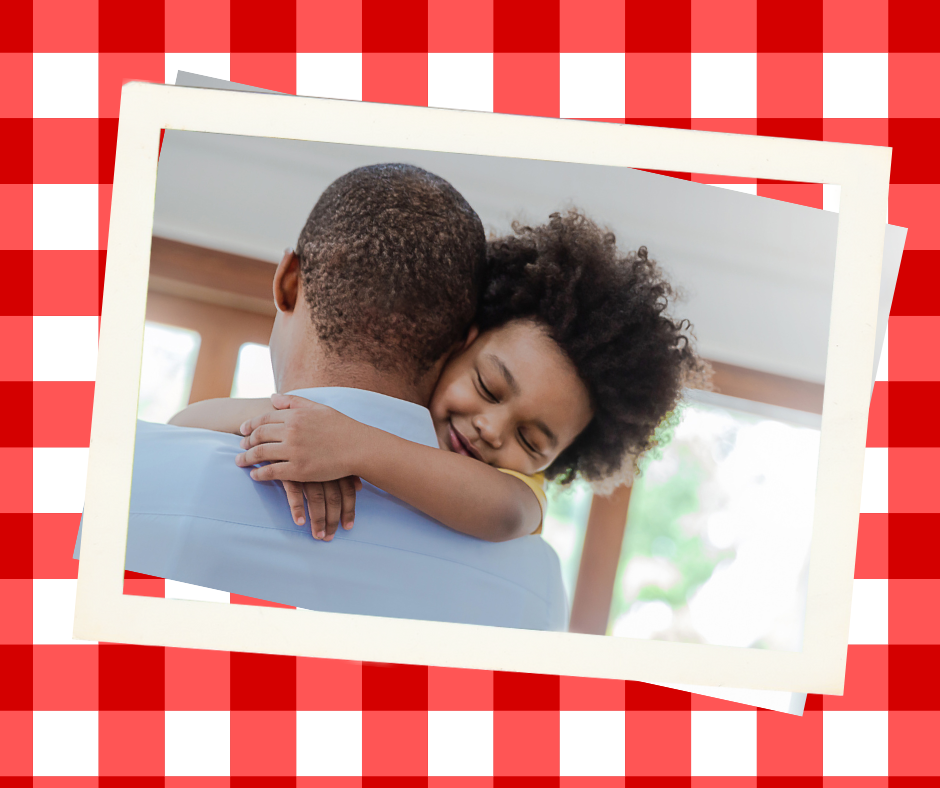 Back of shoulders and head of a black man with child hugging his neck. Front of child's face with smile, closed eyes and hair are visible.